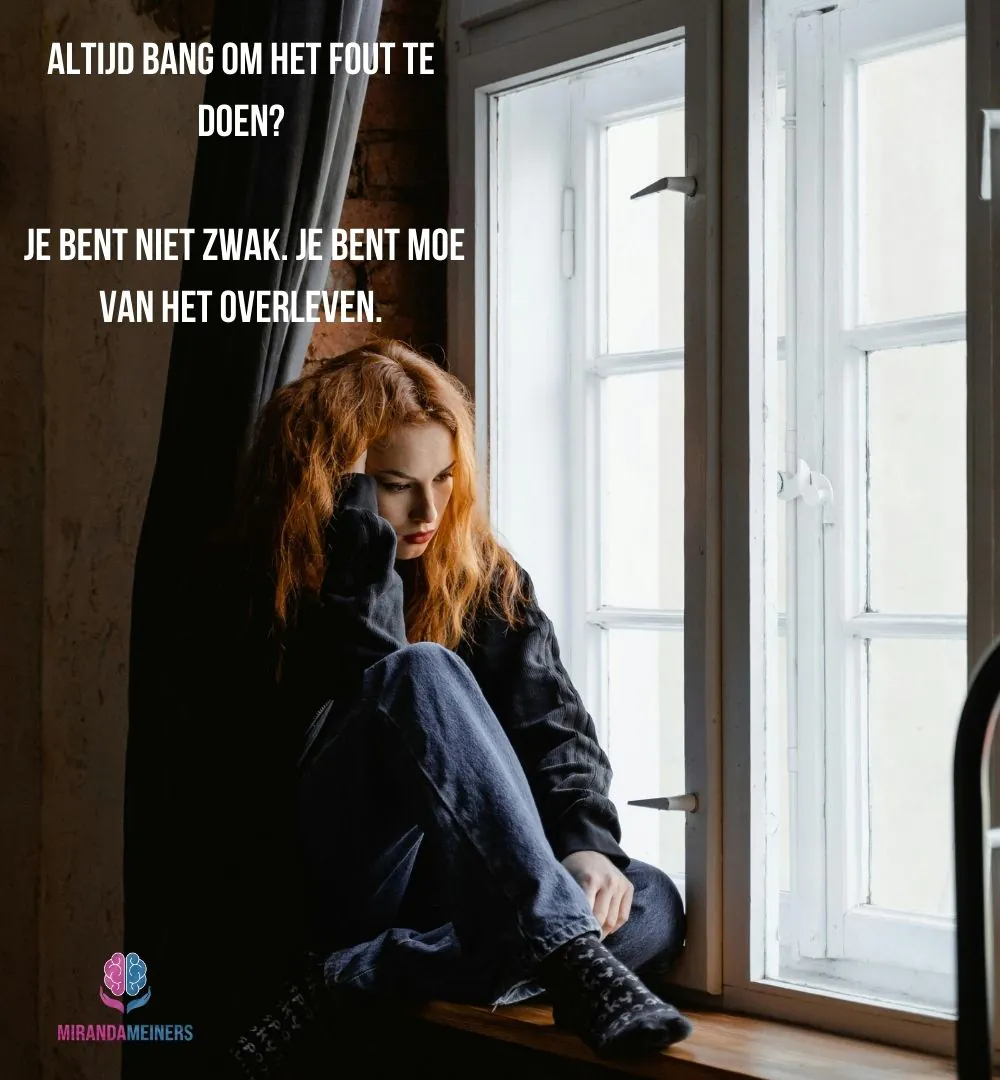 Vrouw met faalangst zit met handen in het haar bij een raam – zoekend naar rust, steun en hulp via hypnotherapie.
