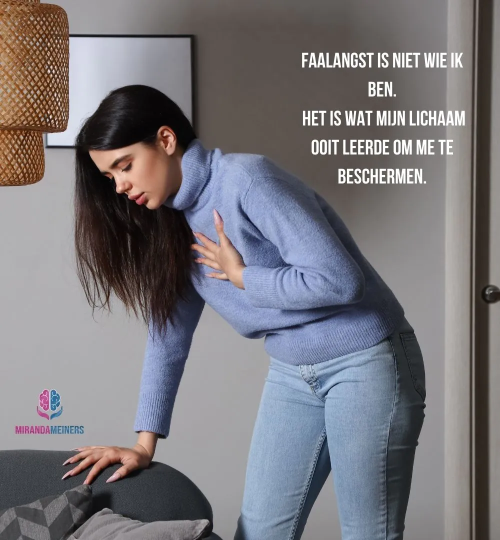 Vrouw met faalangst zit voorovergebogen op bed met haar hand op haar borst – lichamelijke stressreactie zichtbaar in houding en ademhaling.
